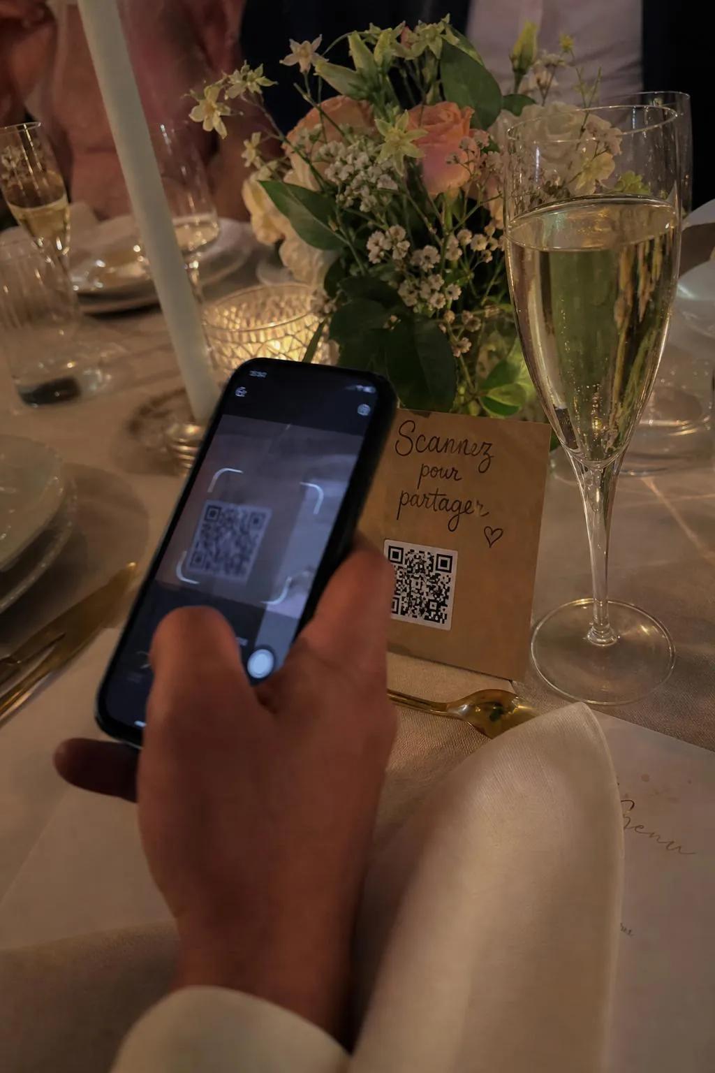 Invité qui scanne le QR code Photora avec son téléphone, à table.